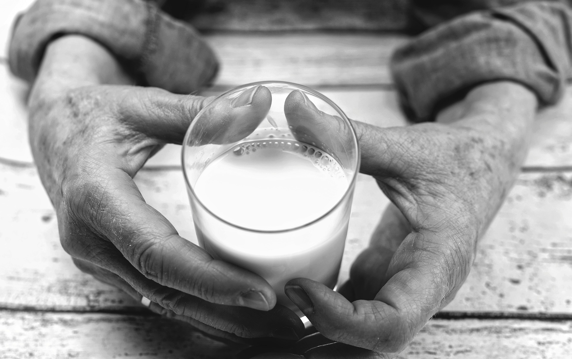 hands holding a glass of milk