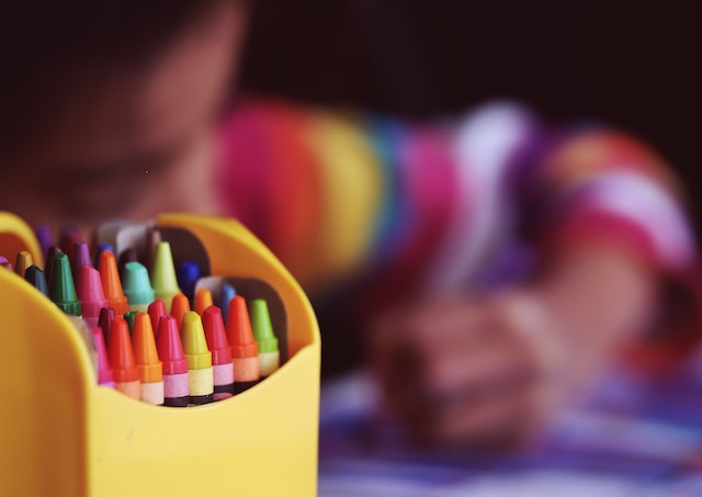 child drawing with crayons
